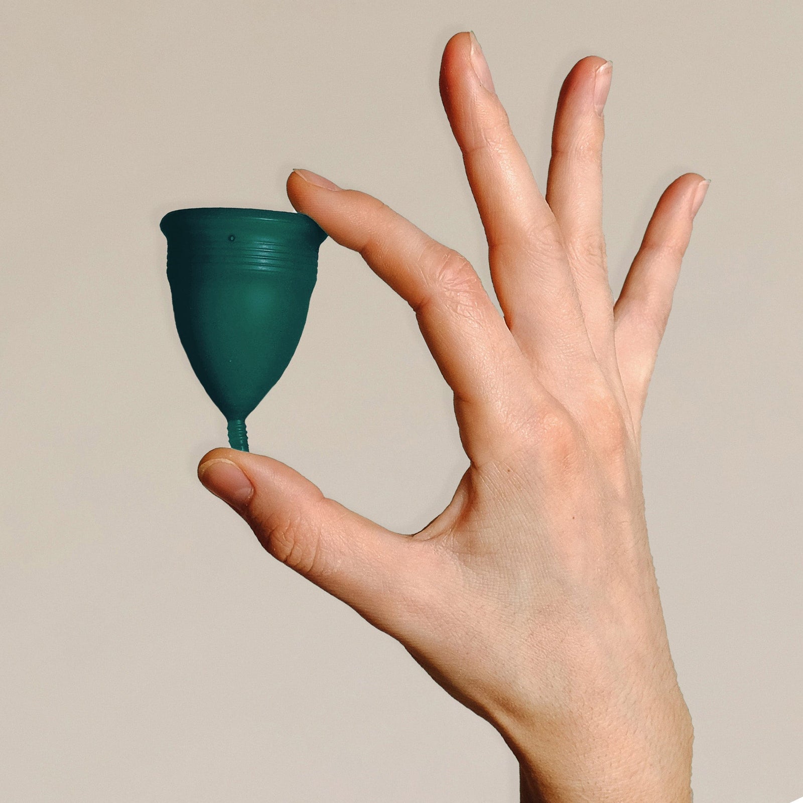 DAME Period Cup® in packaging held by hand, highlighting self-sanitising, vegan, and 12-hour comfort features. Eco-friendly menstrual cup for sustainable care.