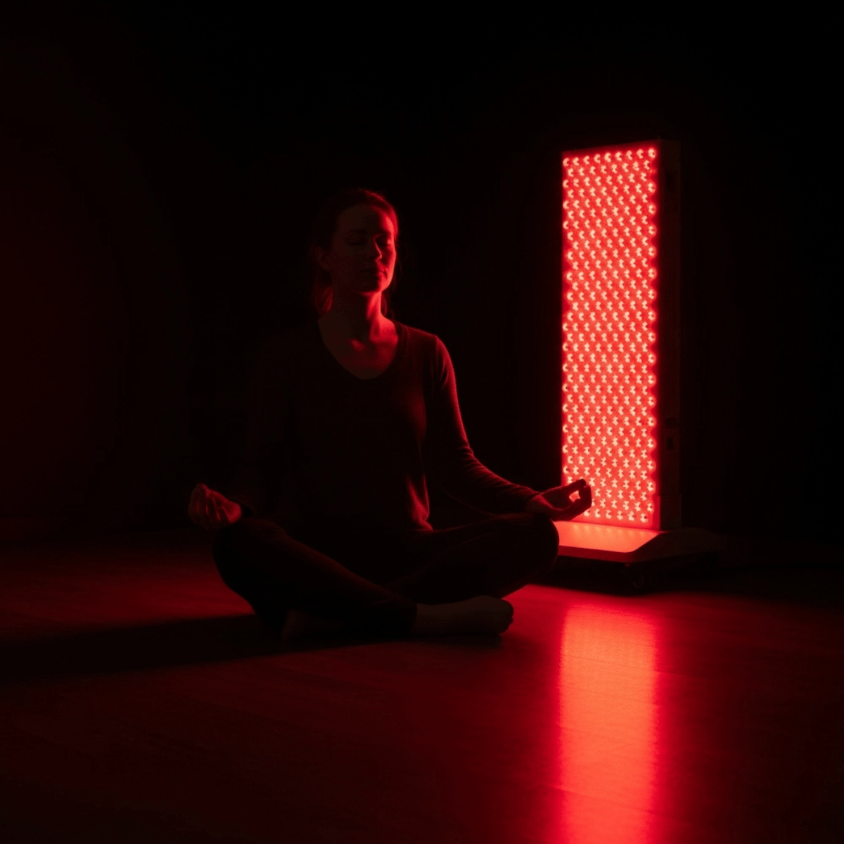 Meditating woman illuminated by the Professional Platinum 7000 - Mvolo Red Light Therapy Panel, promoting relaxation and wellness therapy.