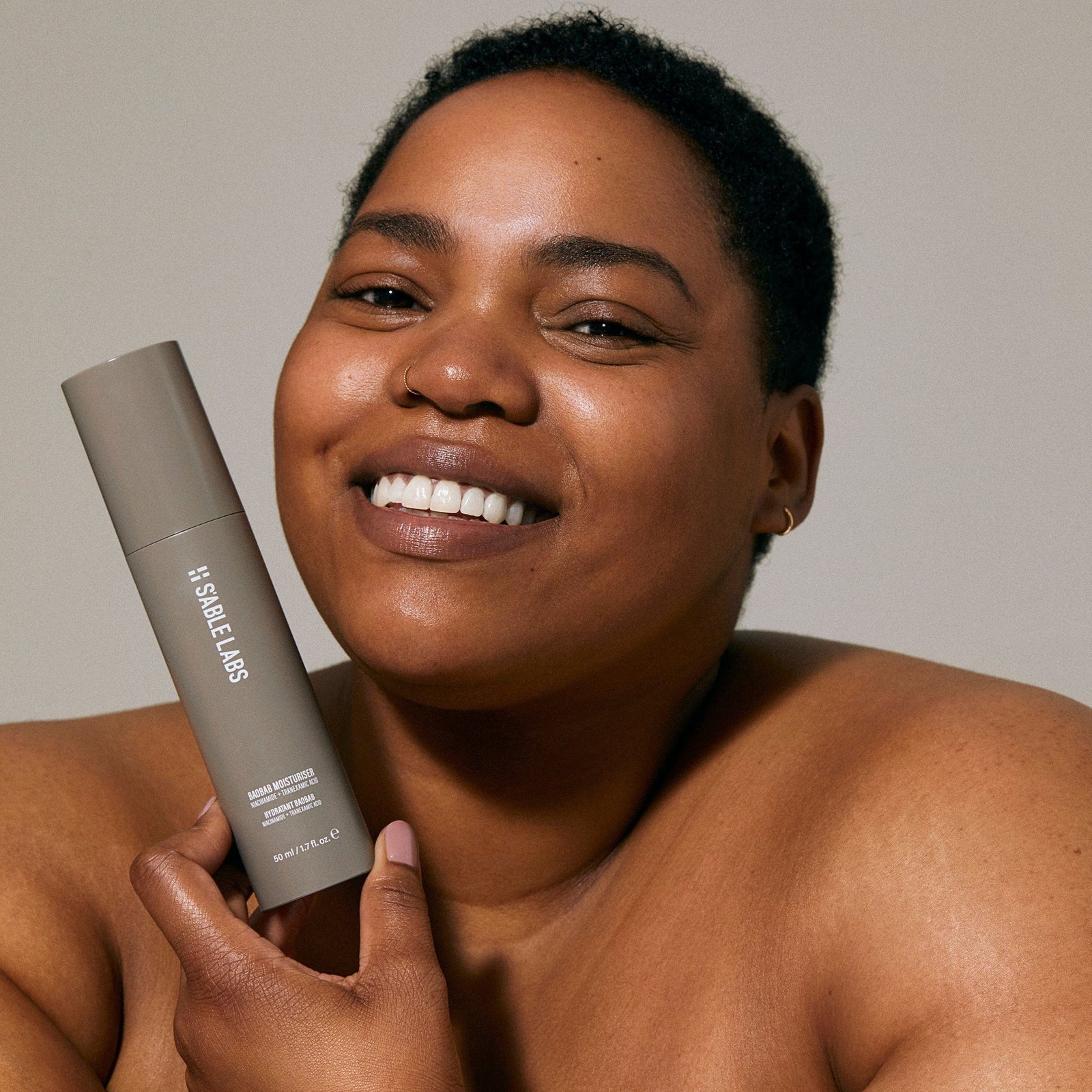 Model holding Baobab Moisturizer Refill by S’Able Labs, a luxury eco-friendly face cream that hydrates and brightens skin for sustainable beauty.