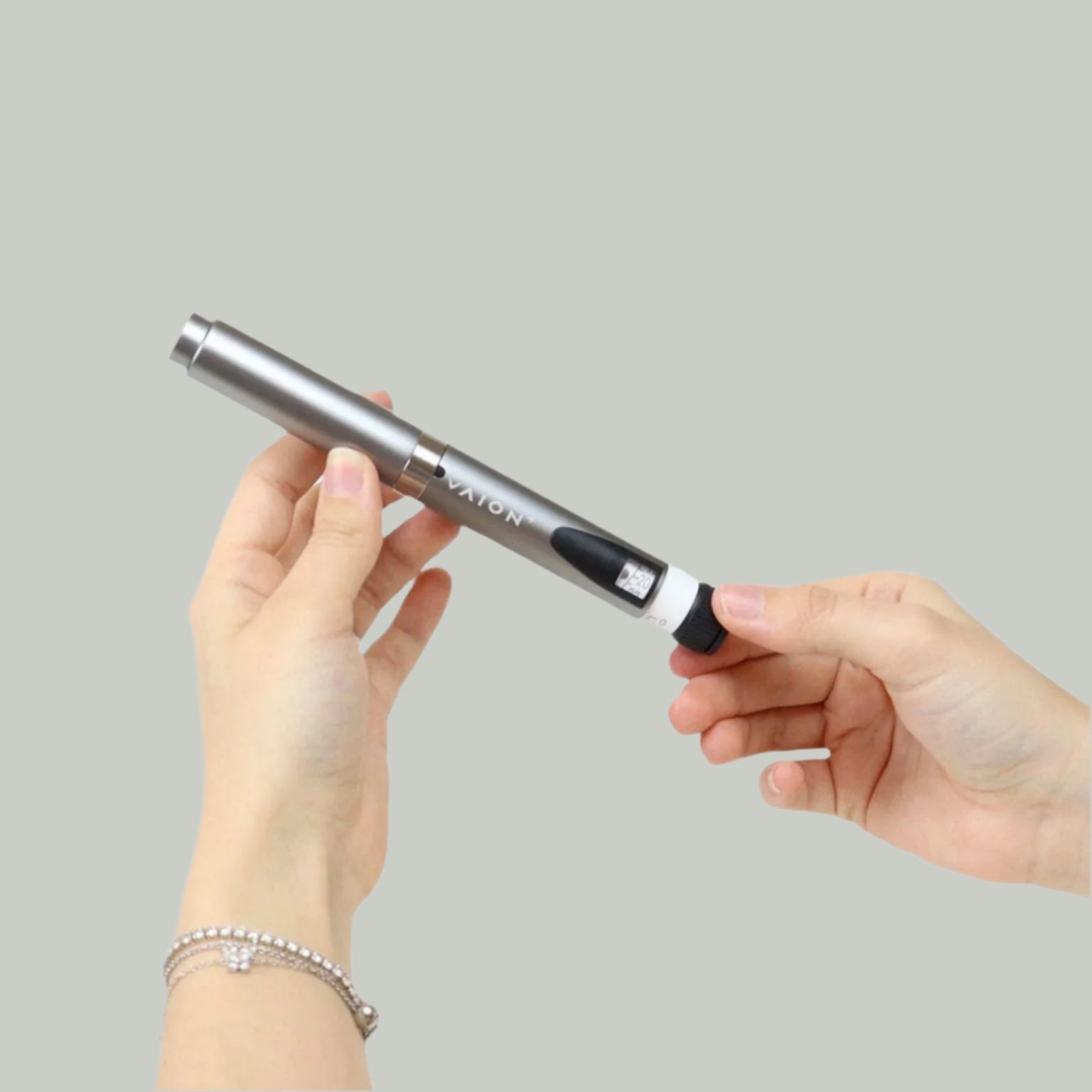 VAION+ NAD Pen - Cellular Wellness Solution | Boosts Energy. Sleek silver wellness pen held by hand, ideal for enhancing energy and focus.