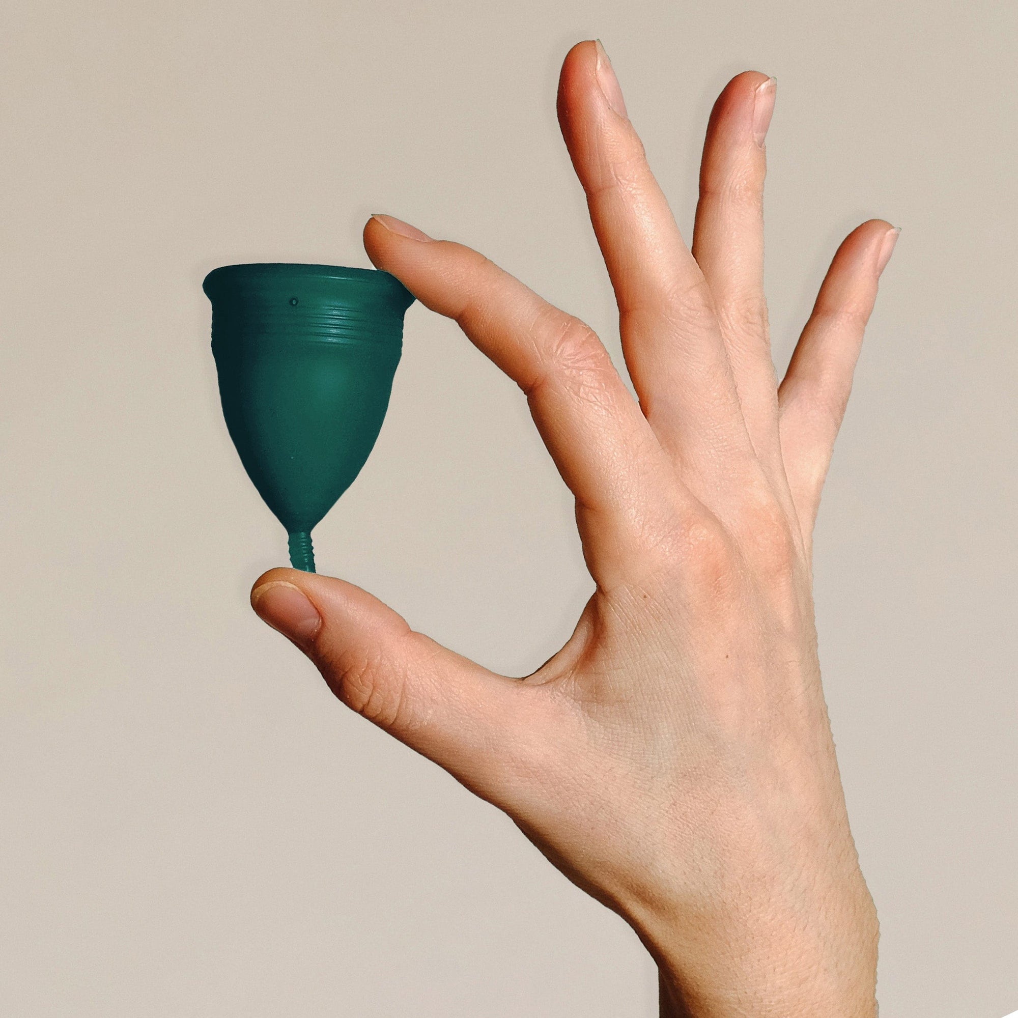 DAME Period Cup® in packaging held by hand, highlighting self-sanitising, vegan, and 12-hour comfort features. Eco-friendly menstrual cup for sustainable care.