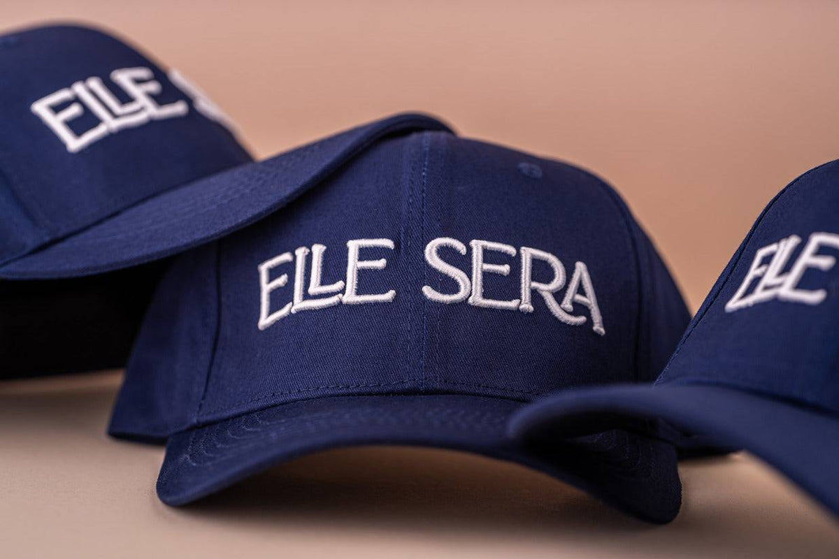 Elle Sera Cap in navy blue with bold white 3D logo embroidery, showcasing a snug fit and durable design. Stylish baseball cap for daily wear.