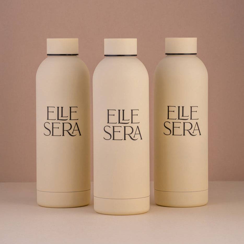 Elle Sera Water Bottle - Stainless Steel | High-Grade Metal in matte beige finish, featuring minimalist branding. Ideal for stylish hydration needs.