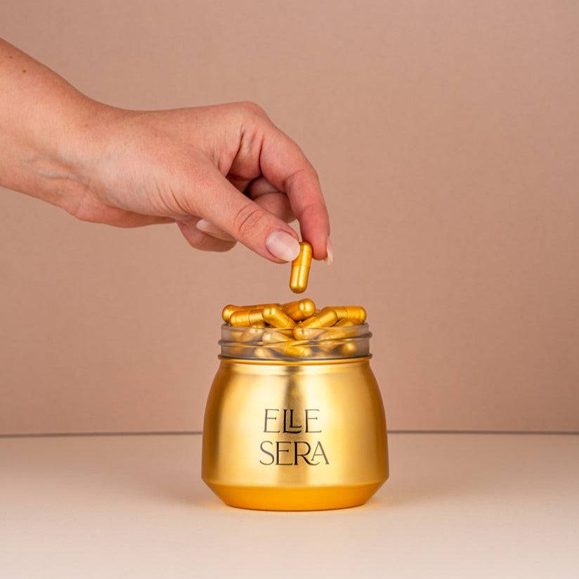 Golden Pill hormone support supplement by Elle Sera with 60 capsules, shown in premium peach pouch and white box packaging for women's vitality.