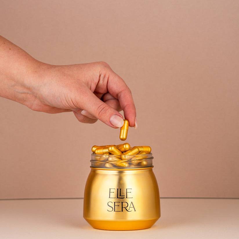 The Golden Pill Gift Set by Elle Sera featuring gold capsules in a jar, three supplement pouches, and a branded box. Energy supplement with no subscription.