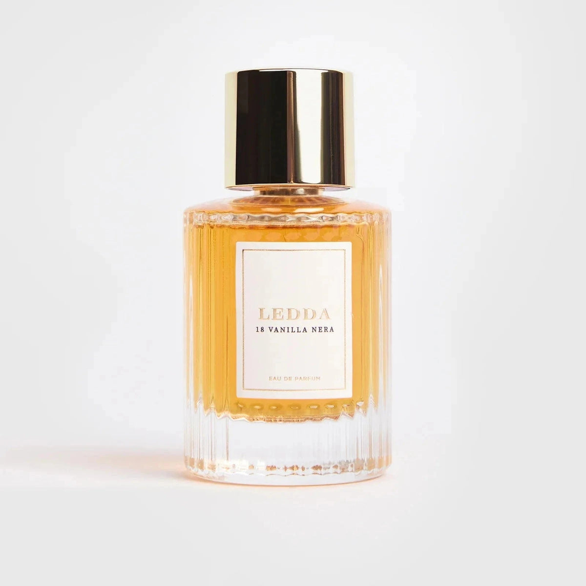 18 Vanilla Nera Eau De Parfum - 50 ML by LEDDA in a clear ribbed glass bottle with gold cap, offering a sweet smoky fragrance blend.