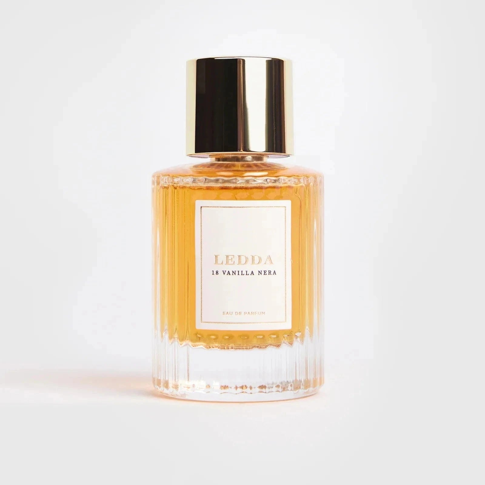 18 Vanilla Nera Eau De Parfum - 50 ML by LEDDA in a clear ribbed glass bottle with gold cap, offering a sweet smoky fragrance blend.