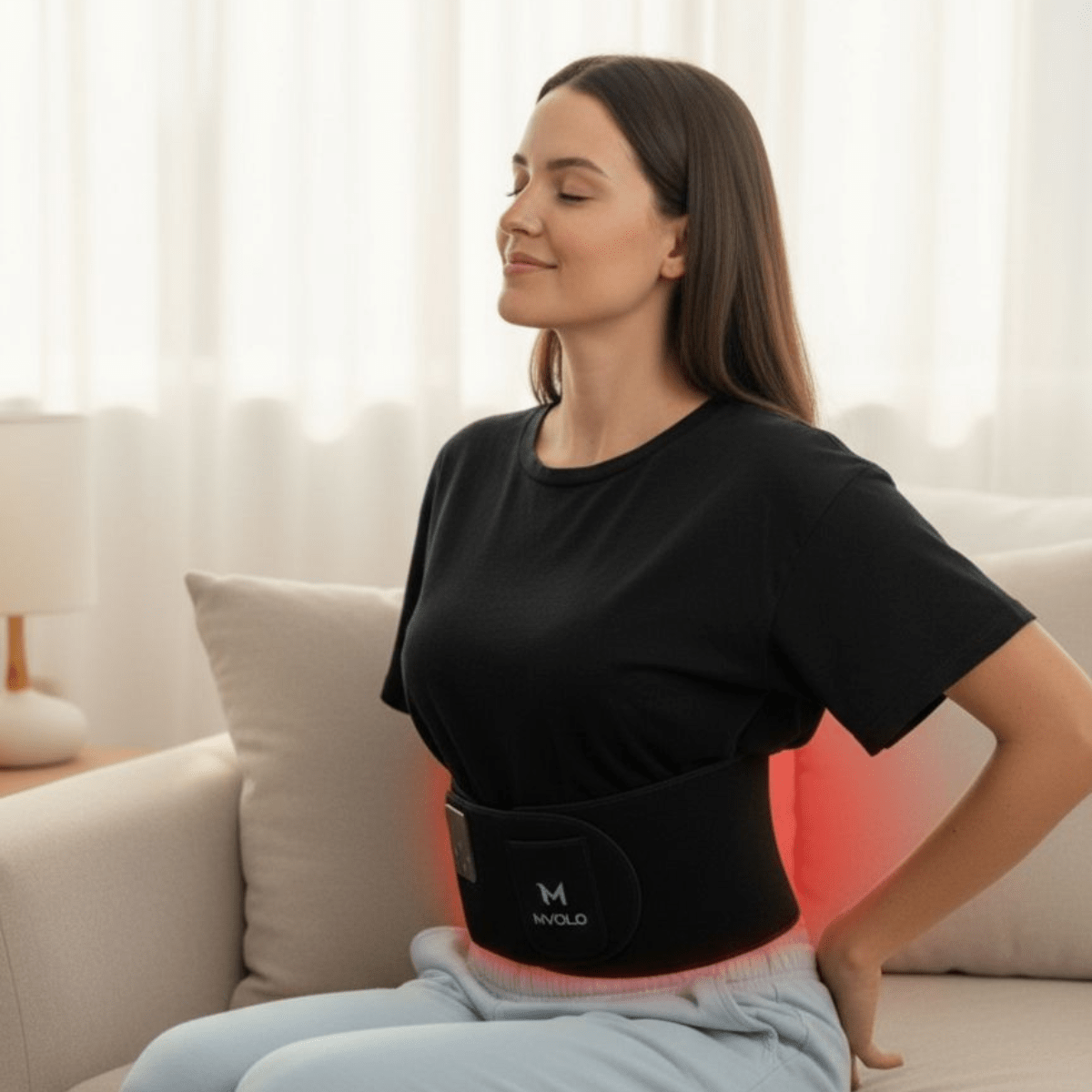 Comfortable Red Light Therapy Band worn by woman on sofa; designed for optimized back pain relief and muscle relaxation.