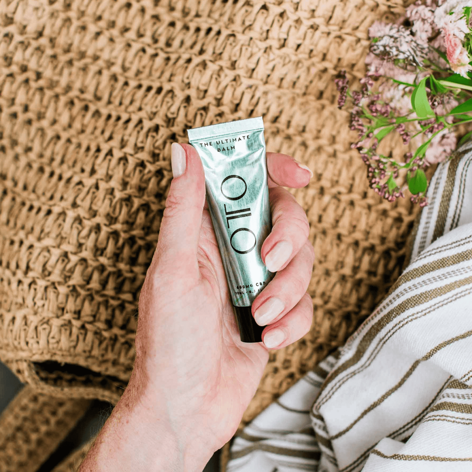 The Ultimate Balm by OTO in a sleek metallic green tube, a luxury multi-purpose skincare balm with 40 uses for deep hydration and skin relief.