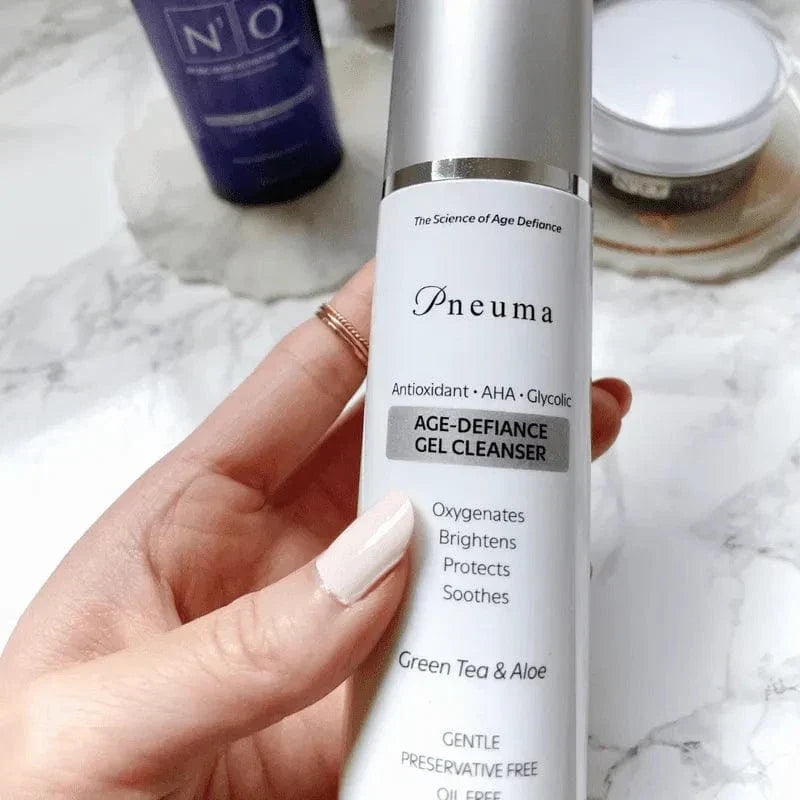 Age-Defiance Gel Cleanser by Pneuma with green tea and aloe in sleek silver pump bottle. Anti-aging botanical formula for gentle daily facial cleansing.