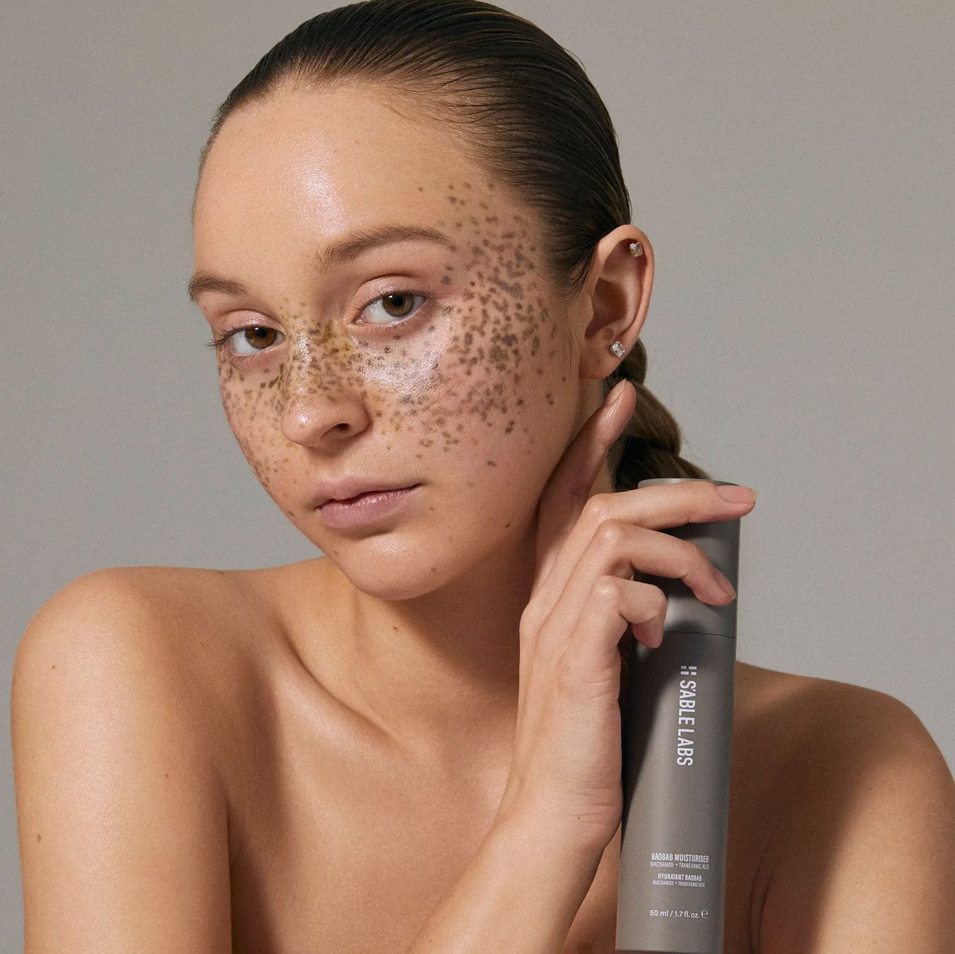 Model holding Baobab Moisturizer Refill by S’Able Labs, a luxury eco-friendly face cream that hydrates and brightens skin for sustainable beauty.