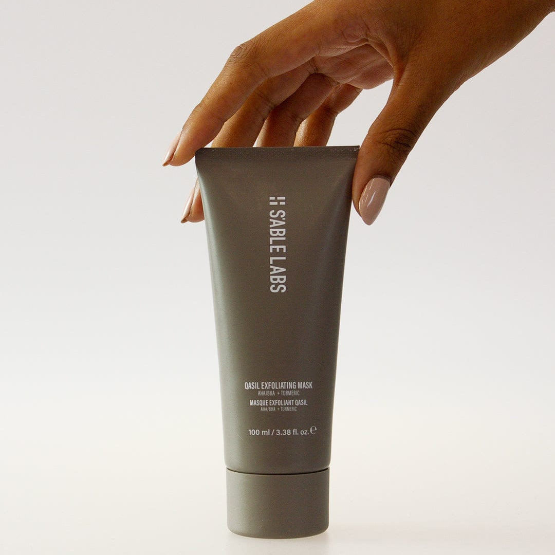 Qasil Exfoliating Mask - Brightening Face Exfoliant | AHAs, PHAs in sleek grey tube held by hand. Natural detoxifying skincare for glowing complexion.